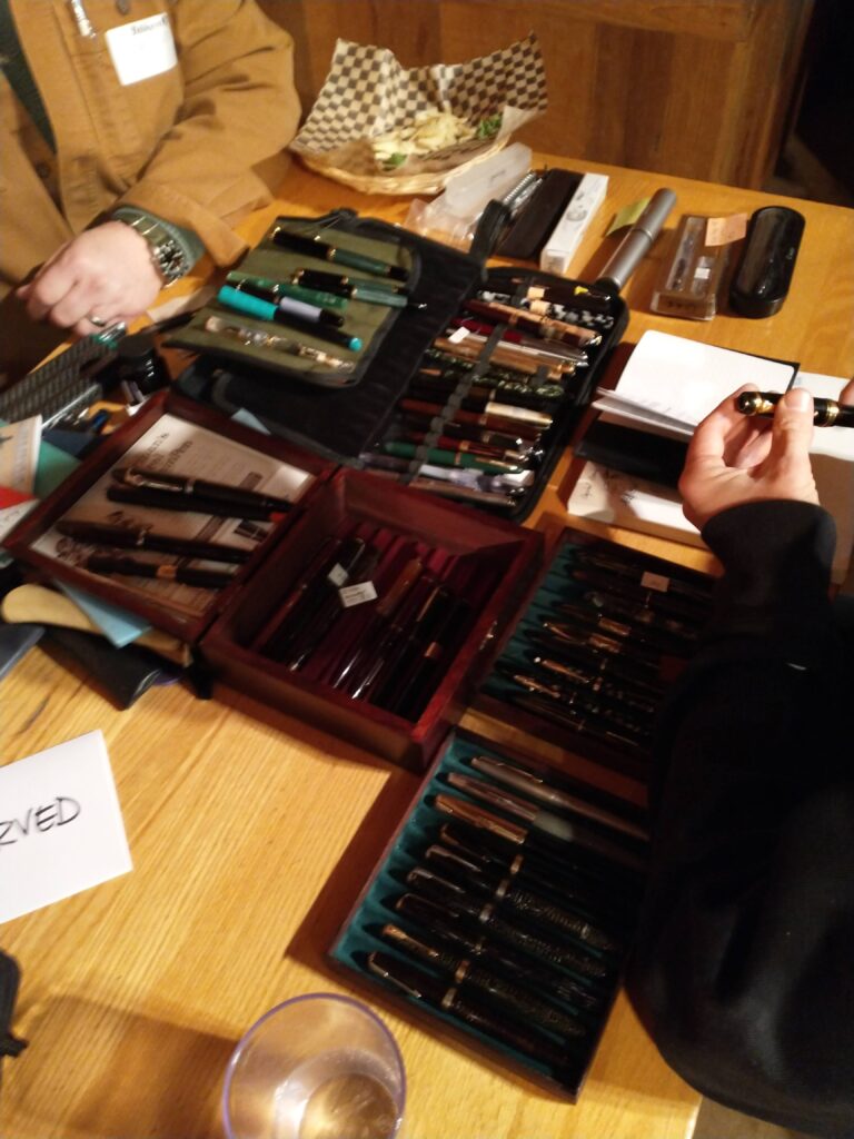 Top down picture of approximately 40 pens in pen cases