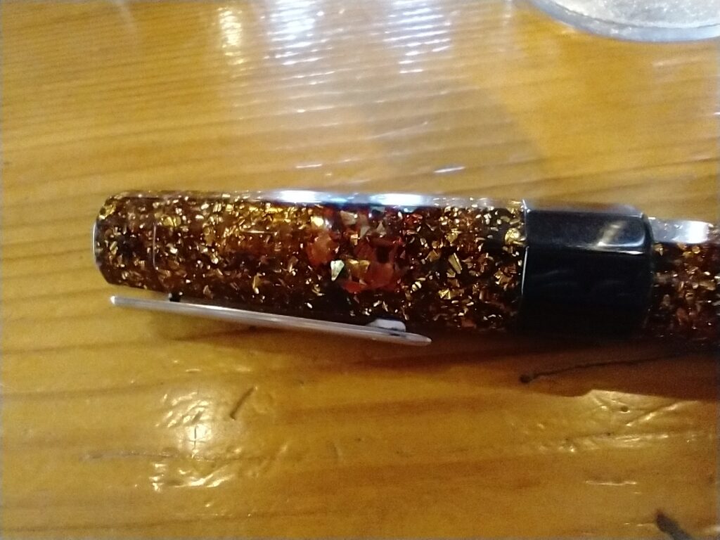 Cap of a sparkly Benu fountain pen, amber